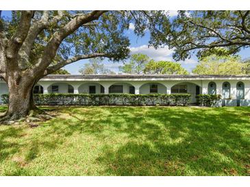 Exterior of a light blue building with a large tree and manicured lawn at 11200 102Nd Ave # 33, Seminole, FL 33778