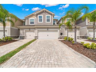 Charming townhomes offer a neutral exterior, lush landscaping, and a brick-paved two-car driveway at 5018 Sunnyside Ln, Bradenton, FL 34211