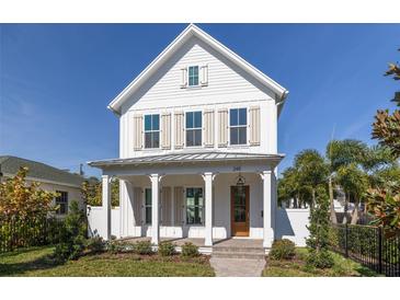 Two-story farmhouse with white siding, shutters, and a metal roof at 245 12Th Ne Ave, St Petersburg, FL 33701