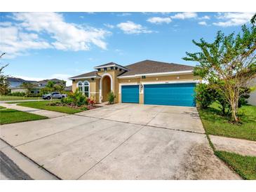 Two-story house with teal garage doors and landscaped yard at 5502 Limelight Dr, Apollo Beach, FL 33572