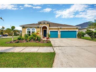 Charming home with a well-manicured lawn and vibrant landscaping, complemented by a two-car garage at 5502 Limelight Dr, Apollo Beach, FL 33572