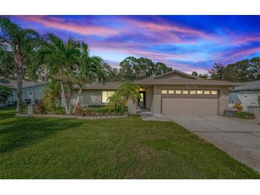 Charming single-story home featuring lush landscaping, a two-car garage, and a well-manicured front lawn at 2342 Hazelwood Ln, Clearwater, FL 33763