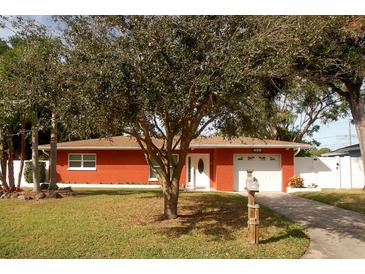 Brick ranch house with attached garage and mature landscaping at 468 Limewood Ave, Dunedin, FL 34698