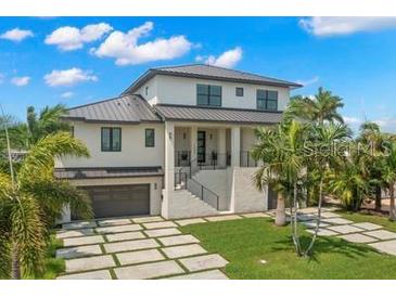 Stunning two-story home boasts modern design, metal roof, and spacious driveway at 7949 2Nd S Ave, St Petersburg, FL 33707