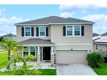 Two-story house with a two-car garage and landscaped lawn at 8277 Bower Bass Cir, Wesley Chapel, FL 33545