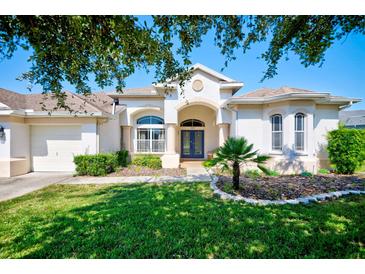 One-story home with attached garage, manicured lawn, and mature trees at 13267 Linzia Ln, Spring Hill, FL 34609