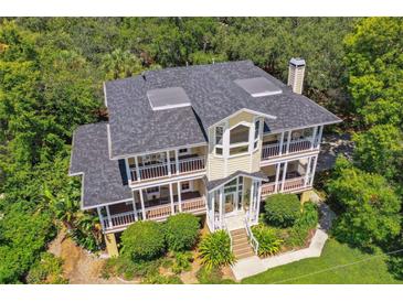 Stunning two-story home with a sprawling porch overlooking lush greenery and a dark roof at 6231 Bayshore Blvd, Tampa, FL 33611