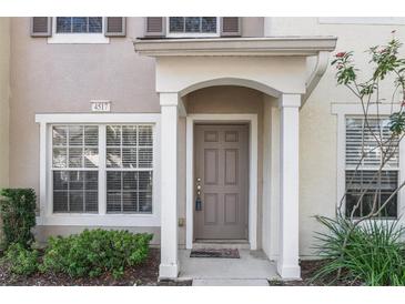 Tan two-story townhome with a brown door and landscaping at 4517 Kennewick Pl, Riverview, FL 33578