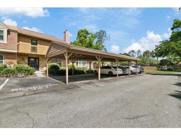 View of a multi-car carport with reserved parking spots in front of the building at 5325 Bradbury Ct, Tampa, FL 33624