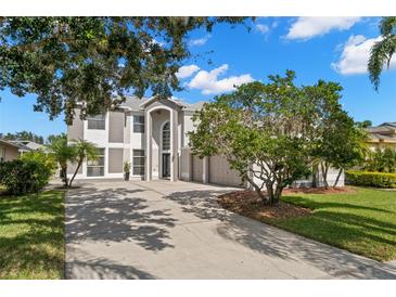 Two-story house with a three-car garage and manicured lawn at 4915 Augusta Ave, Oldsmar, FL 34677