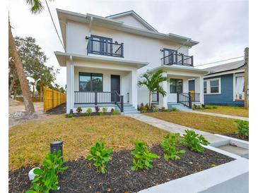 Two-story duplex with modern design, landscaping, and paved walkways at 1906 Cherry W St # 1, Tampa, FL 33607