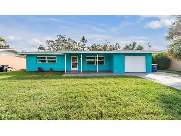 Charming ranch home with turquoise exterior, attached garage, and spacious lawn at 2315 Nash St, Clearwater, FL 33765