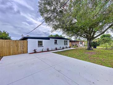 Newly renovated home with a large concrete driveway and a fenced-in yard at 4008 W Olive St, Tampa, FL 33616