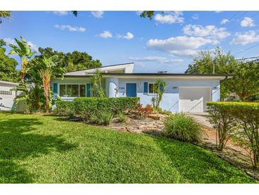 Cute light blue house with well-maintained landscaping at 5101 W Platt St, Tampa, FL 33609