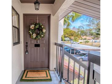 Inviting condo entry with wreath and view of lush landscaping at 3505 Tarpon Woods Blvd # K409, Palm Harbor, FL 34685