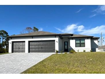 New construction home with three-car garage and attractive landscaping at 12140 Warden Ave, Port Charlotte, FL 33981