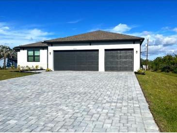 Two-story house with a three-car garage and a paved driveway at 4570 Gillot Blvd, Port Charlotte, FL 33981