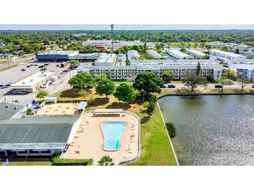 Aerial view of community with pool, lake, and buildings at 5875 21St N St # 15L, St Petersburg, FL 33714