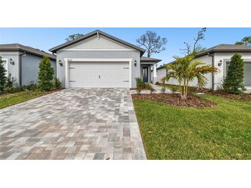 House exterior featuring a two-car garage and well-manicured lawn at 9430 Shorebird Ct, Parrish, FL 34219