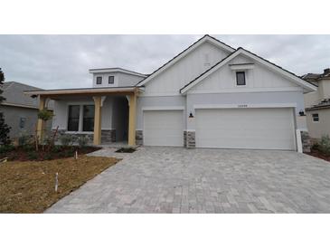 Two-story house with white siding, gray stone accents, and a paved driveway at 18096 Foxtail Loop, Venice, FL 34293