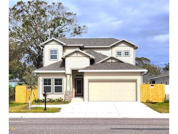 Two-story house with beige siding, gray roof, and a two-car garage at 3033 54Th N Ave, St Petersburg, FL 33714