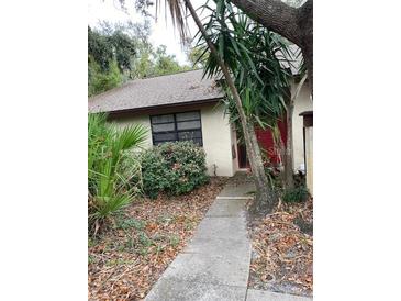 Ranch-style home with a red door and walkway at 2953 Yucca Ct, Palm Harbor, FL 34684