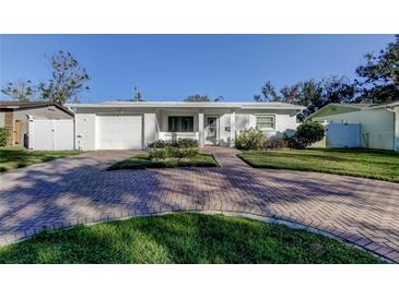 Cute bungalow with brick driveway, white exterior, and well-manicured lawn at 8495 109Th St, Seminole, FL 33772