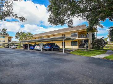 Charming condo building with covered parking in a well-maintained community with blue skies and mature trees at 12300 Vonn Rd # 9105, Largo, FL 33774