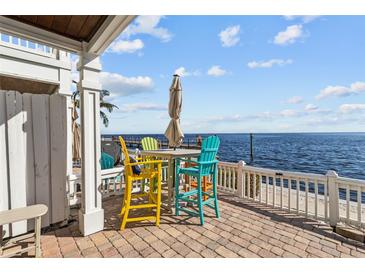 Enjoy waterfront views from this patio, featuring colorful seating and a brick-paved surface at 5026 Coquina Key Se Dr # 5026, St Petersburg, FL 33705