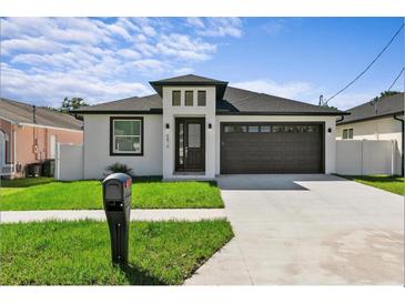 Single-story home with dark brown garage door and mailbox at 7214 N Blossom Ave, Tampa, FL 33614