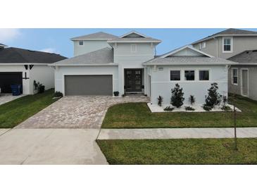 Two-story home with gray siding, brown garage door, and landscaped front yard at 8441 Ivy Stark Blvd, Wesley Chapel, FL 33545