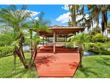 Relaxing lakefront patio with a covered bar and seating area at 20333 Moss Branch Ct, Lutz, FL 33558