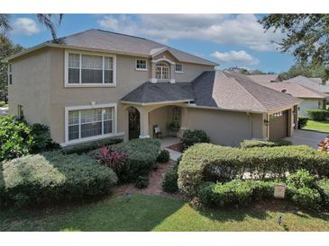 Two-story house with a landscaped yard, two-car garage, and large windows at 5315 Cedarshake Ln, Valrico, FL 33596