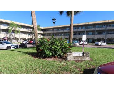 Building exterior, featuring landscaped grounds and parking at 2462 Brazilia Dr # 20, Clearwater, FL 33763