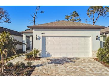 White garage door and paved driveway of a new home at 9442 Shorebird Ct, Parrish, FL 34219