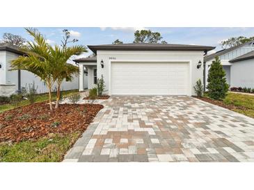 White house exterior with a two-car garage and landscaped front yard at 9446 Shorebird Ct, Parrish, FL 34219