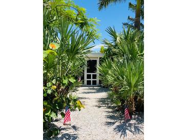 Inviting entryway to charming home, lush tropical landscaping at 105 162Nd Ave, Redington Beach, FL 33708