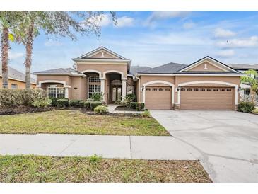 Two-story house with a three-car garage and landscaped yard at 19230 Climbing Aster Dr, Tampa, FL 33647