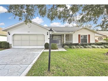 Charming single-story home with a two-car garage, well-manicured lawn, and mature landscaping at 7231 Big Bend Dr, Spring Hill, FL 34606