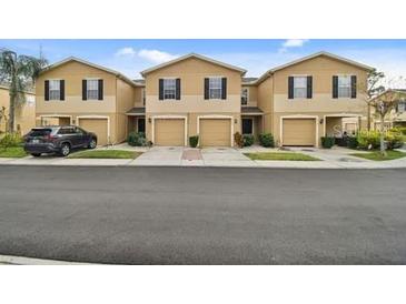 Front view of townhouses with attached garages and neat landscaping at 7916 Longwood Run Ln, Tampa, FL 33615