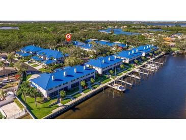 Beautiful waterfront condo complex featuring private boat docks, manicured lawns, and vibrant blue roofs at 1688 Watermark Ne Cir # 1688, St Petersburg, FL 33702