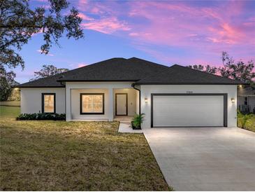 One-story home with attached garage, neutral color palette, and landscaping at 5364 Boxtree Ct, Dade City, FL 33523