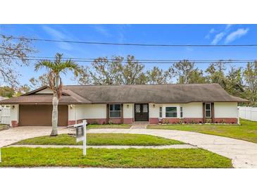 Newly renovated single-Gathering home with a brown garage door and landscaped yard at 1557 Jeffords St, Clearwater, FL 33756