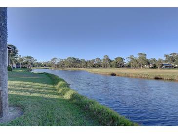 Serene canal-front view with lush landscaping and clear blue water at 4452 Weybridge St # 74, Sarasota, FL 34235