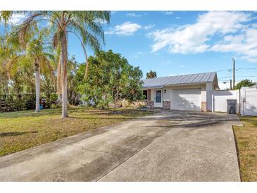 House exterior with driveway, landscaping, and metal roof at 6598 26Th N St, St Petersburg, FL 33702