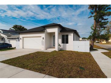 Newly constructed home with modern facade, driveway, and landscaped lawn at 2513 W Hiawatha St, Tampa, FL 33614