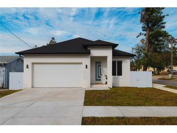 Modern house with white exterior, black roof, and a two-car garage at 2513 W Hiawatha St, Tampa, FL 33614