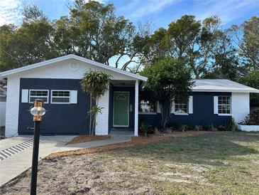 Newly renovated home with a charming curb appeal, featuring a fresh coat of paint and landscaping at 5703 S Sheridan Rd, Tampa, FL 33611