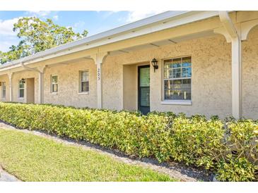 Front view of a condo building, featuring a well-manicured lawn and shrubbery at 2465 Northside Dr # 205, Clearwater, FL 33761