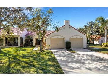 Spanish style home with two car garage and lush landscaping at 1120 Tartan Dr, Palm Harbor, FL 34684